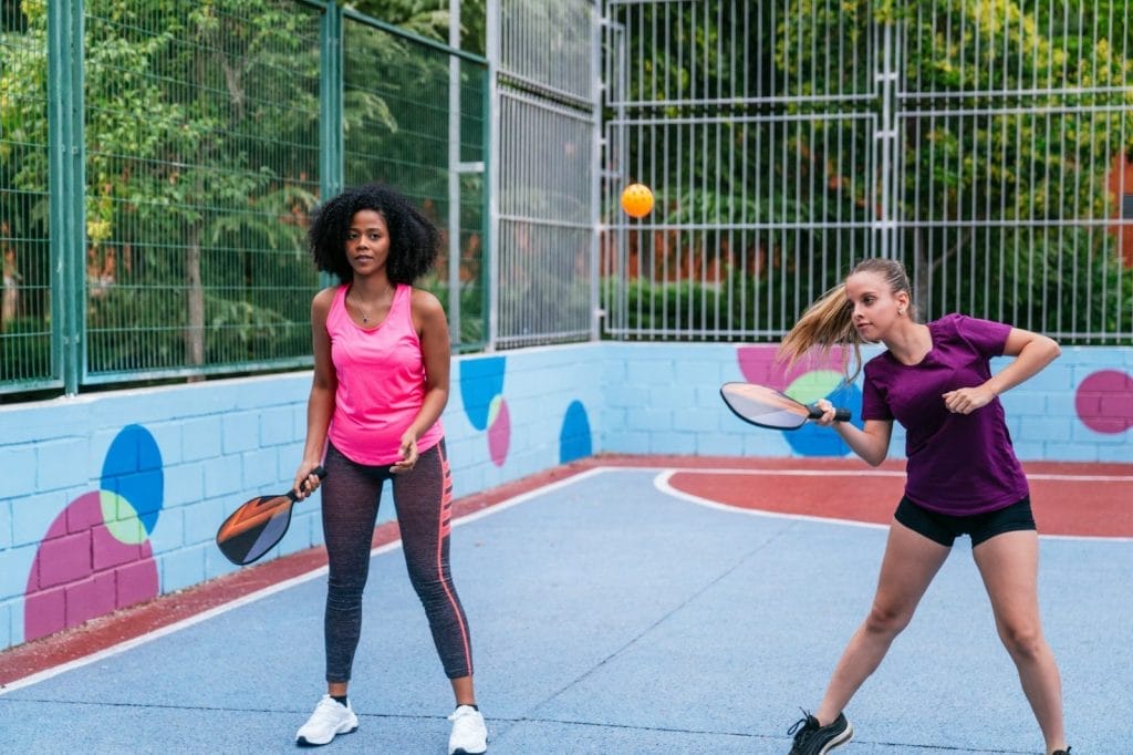 Multiethnic female athletes playing pickleball outdoors